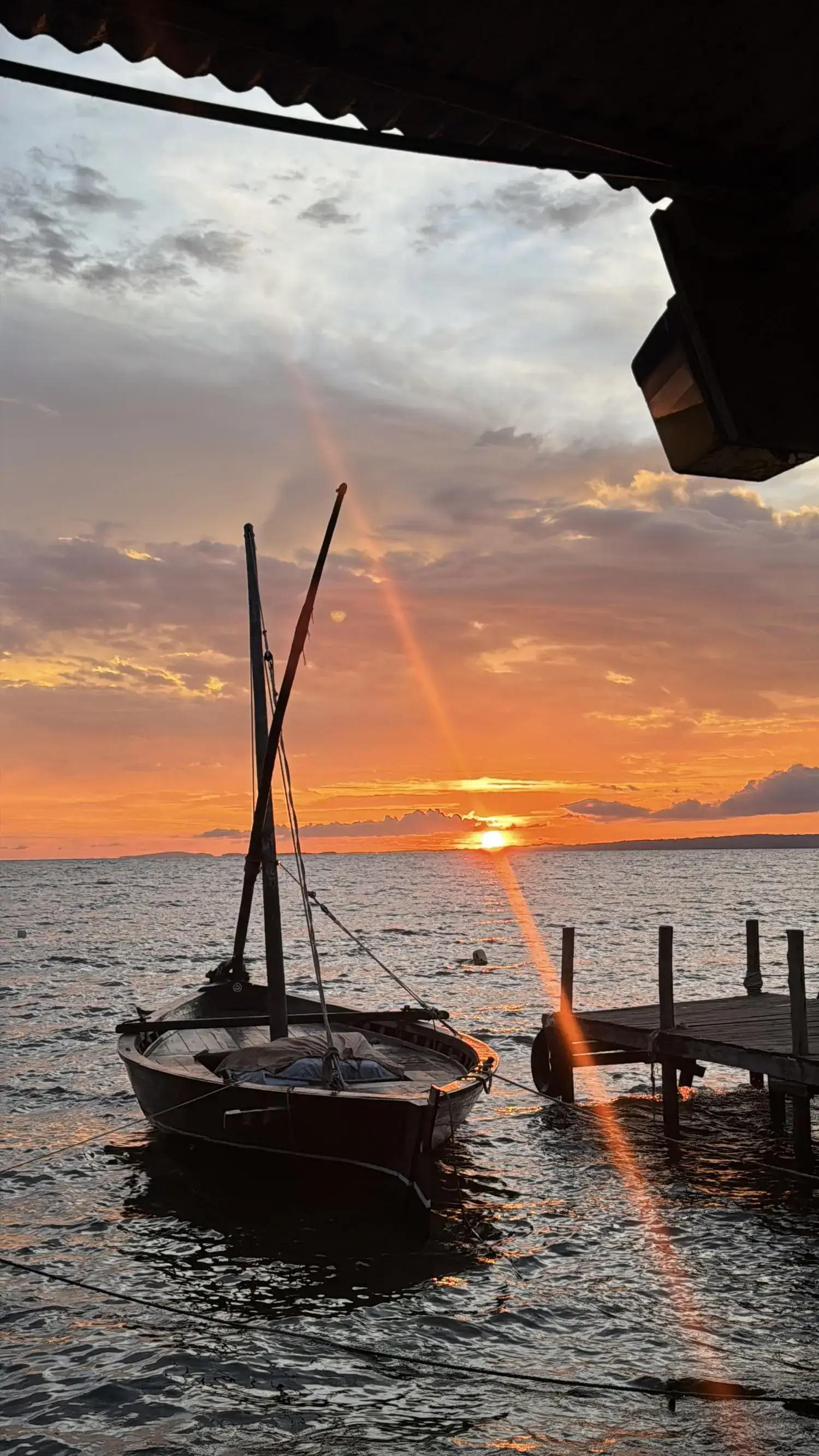 A dhow moored beside the jetty at sunset on Lake Victoria