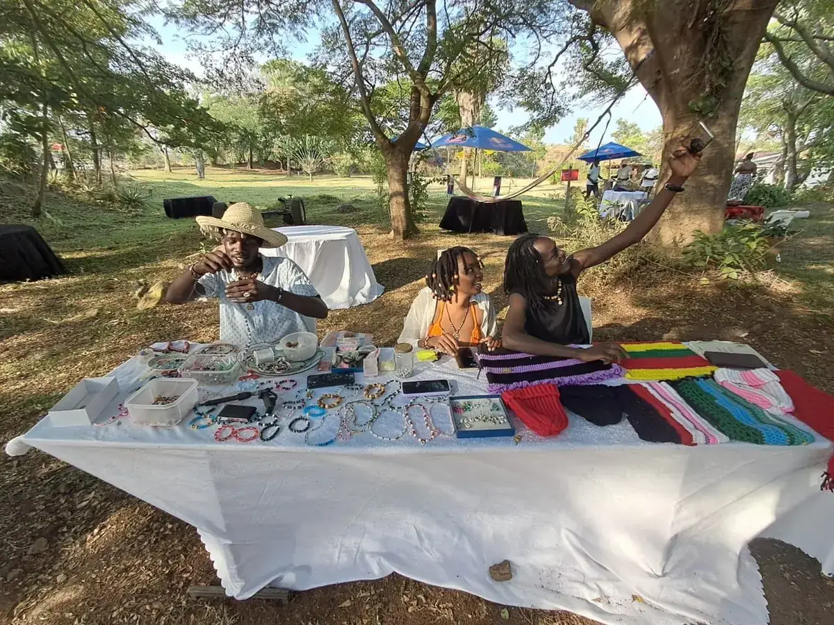 Handmade jewellery and crochet on a market table under the trees